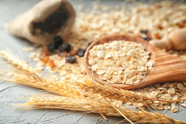 Wooden spoon with oatmeal flakes on table