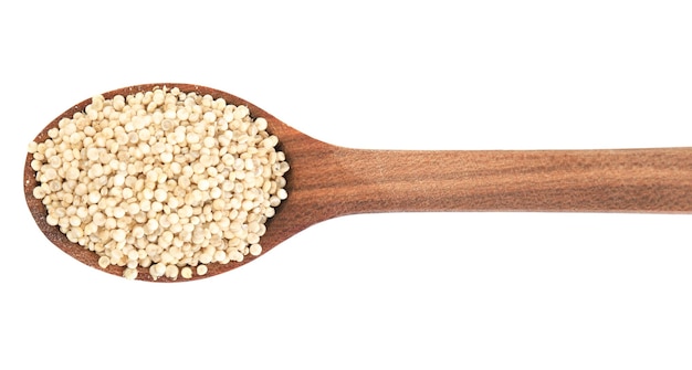 Wooden spoon with quinoa on white background top view