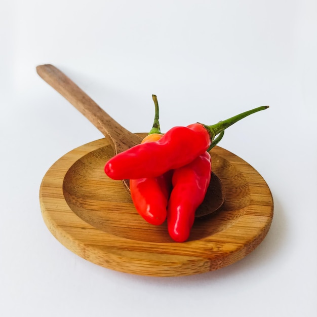 Photo a wooden spoon with a red pepper on it