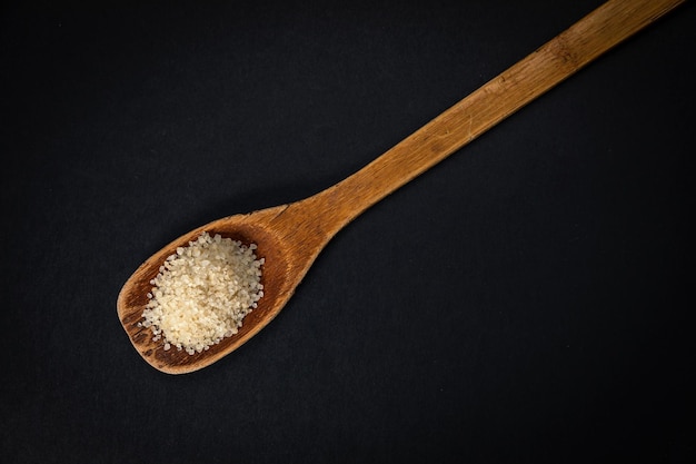 wooden spoon with salt and spices on a dark background