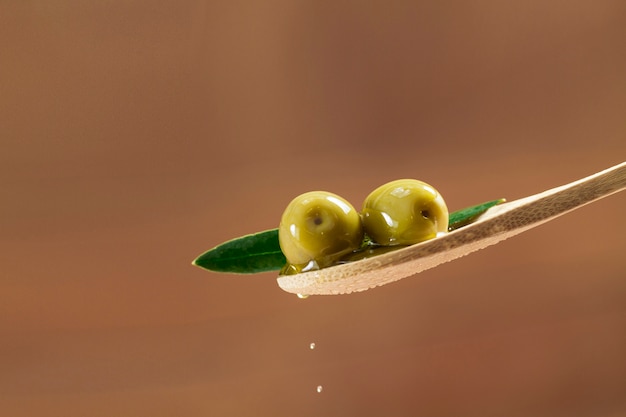 Photo wooden spoon with two olives