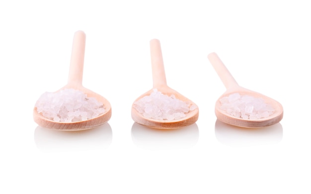 Wooden spoon with a white salt bath carved on a white background