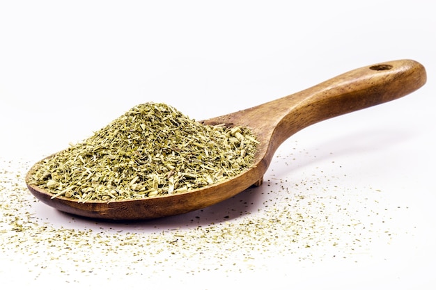 Cucchiaio di legno con yerba mate su sfondo bianco isolato