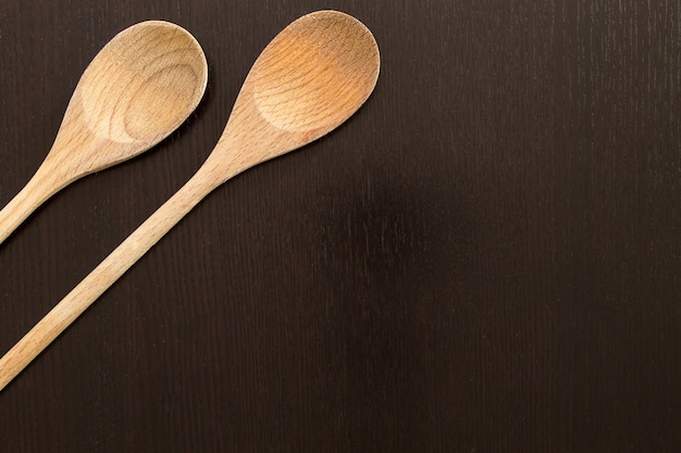 Wooden spoons on black table. Kitchen tools close up