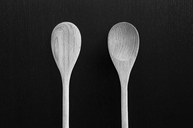 Wooden spoons on black table Kitchen tools close up