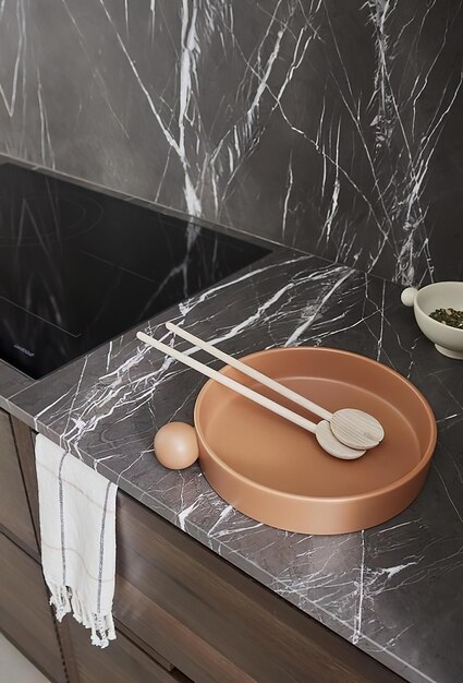 Wooden spoons in ceramic plate in kitchen interior Modern kitchen interior in black marble colors