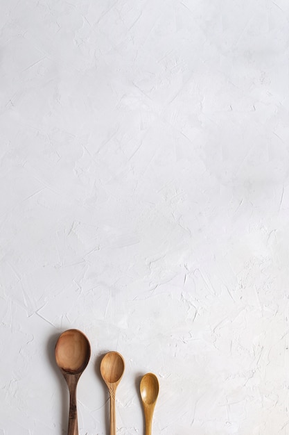 wooden spoons on concrete white background.