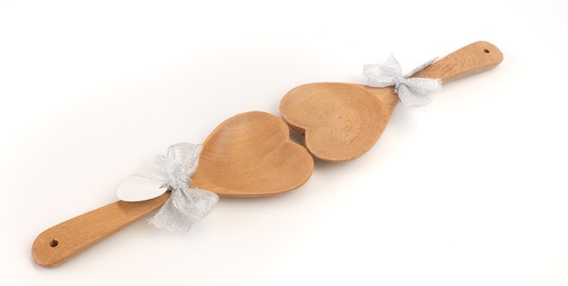 Wooden spoons in heart shape with paper for text on white