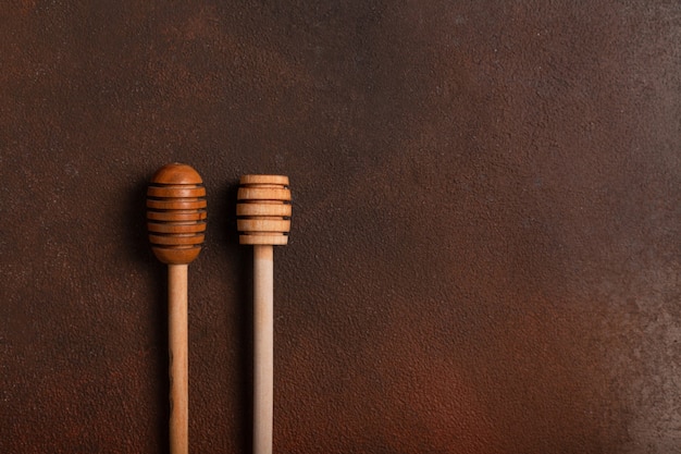 Wooden spoons for honey on a dark table