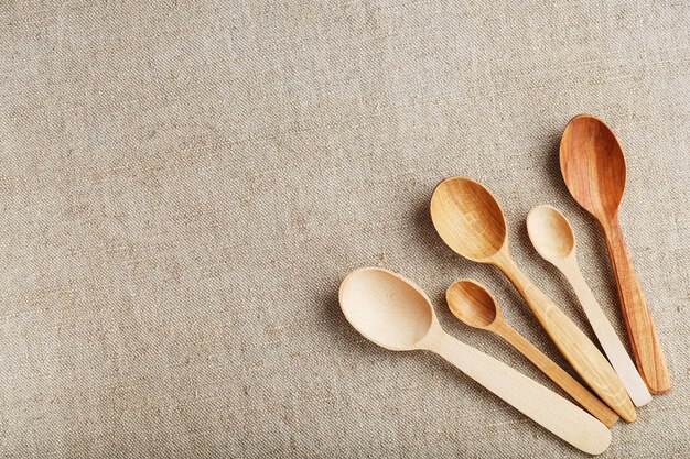 Wooden spoons made of natural wood on burlap fabric as a craft.
natural natural materials. caring for the environment