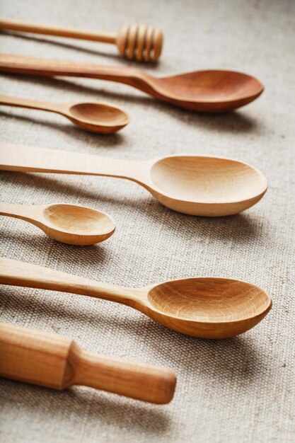 Wooden spoons made of natural wood on burlap fabric as a craft.