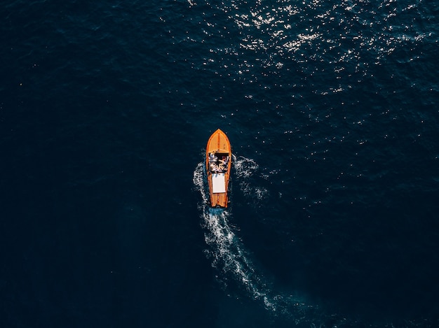 人々が乗船している木製のスポーツボートが海に乗ります。豪華な木製モーターボート-からの上面図