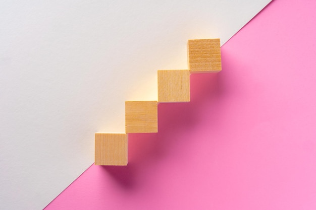 Wooden square block on pink and white background