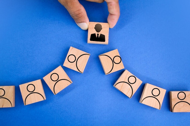 wooden square with leader and employee icons. the concept of following the leader. organization