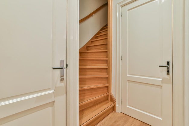 A wooden staircase in a hallway with wooden floor