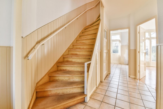 Wooden staircase in spacious hall of apartment