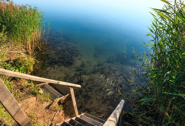 Wooden stairs to summer lake