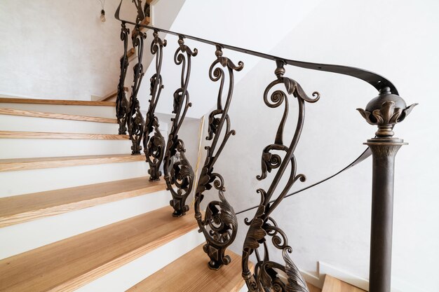 Wooden stairs with metal wrought iron railings in a new\
house