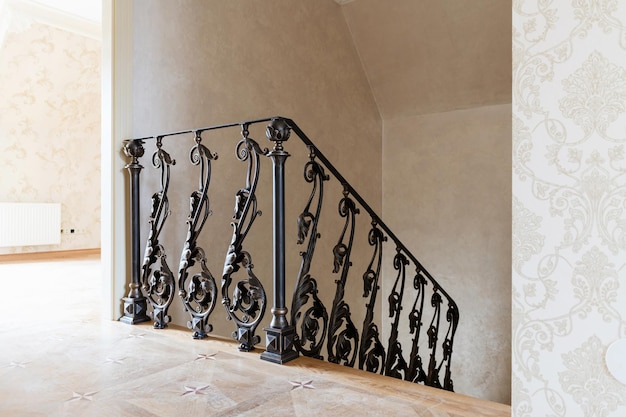 Wooden stairs with metal wrought iron railings in a new\
house