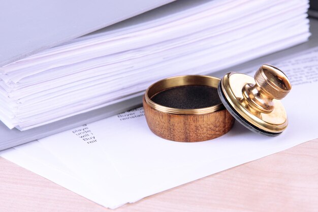 Photo wooden stamp and papers on table