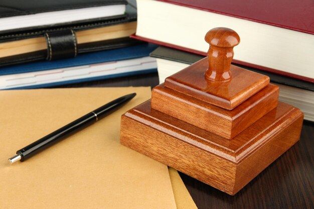 Photo wooden stamp with notepads and books on table