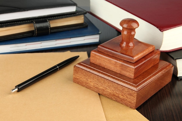 Wooden stamp with notepads and books on table