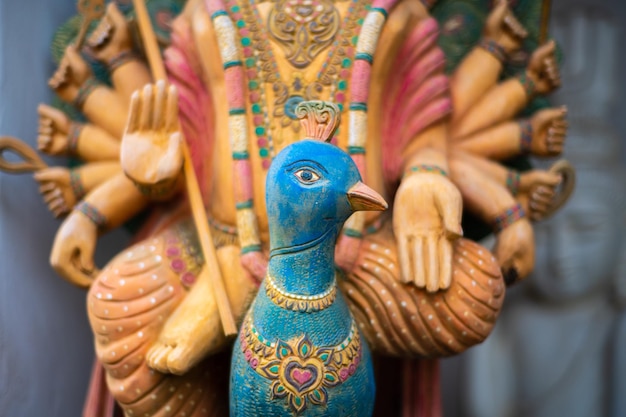 Wooden statue of Hindu god Murugan riding a peacock