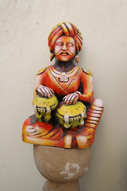 A wooden statue of a man playing drums
