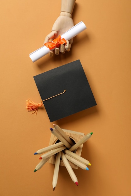 Foto statuetta in legno di un uomo con un cappello di laurea e un diploma