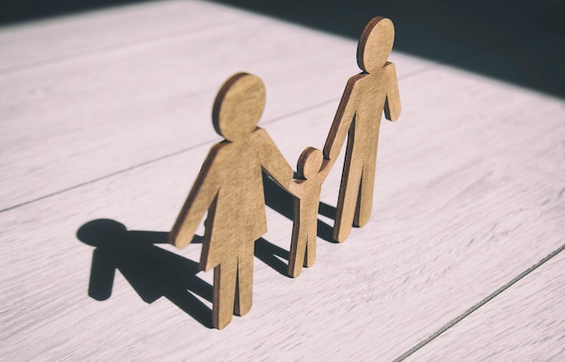 Foto statuette in legno di madre, padre e figlio sul pavimento di legno