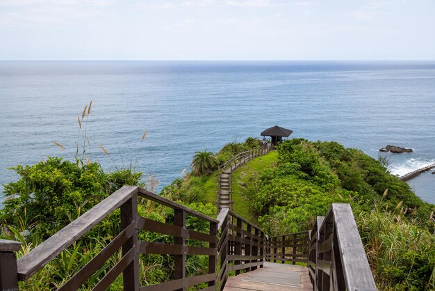 Wooden step hiking trail over the mountain with the sea view