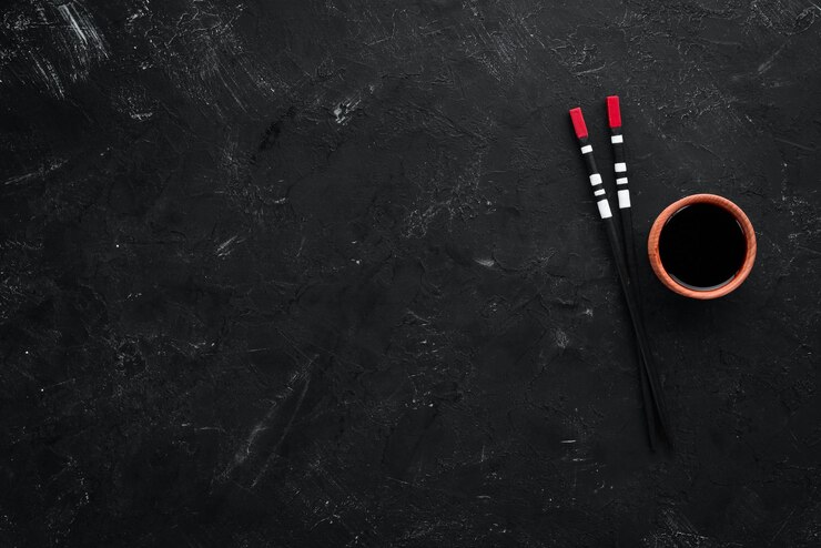 Photo wooden sticks for asian food on a black background top view free copy space