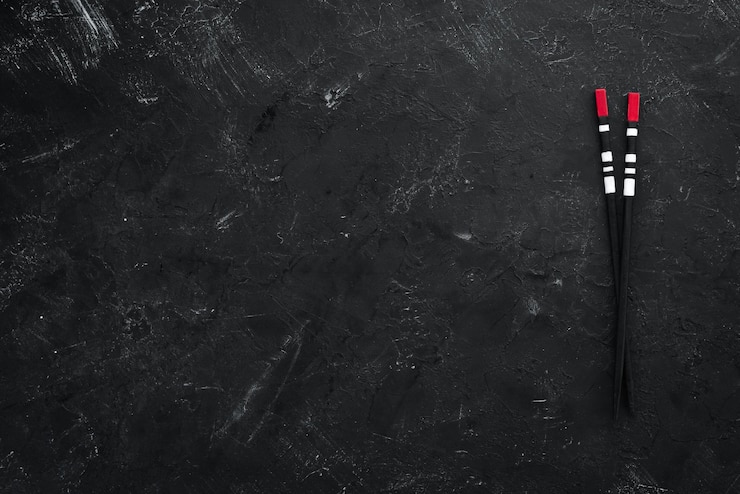 Photo wooden sticks for asian food on a black background top view free copy space
