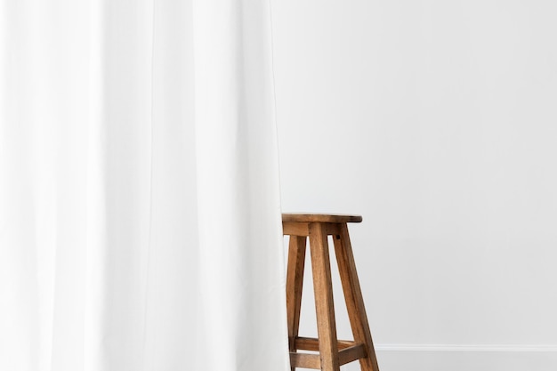 Photo wooden stool behind a white curtain