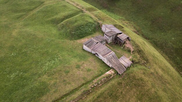 Wooden structure on a green field top view from the drone