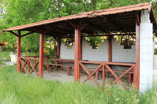 Photo a wooden structure with a roof and a bench