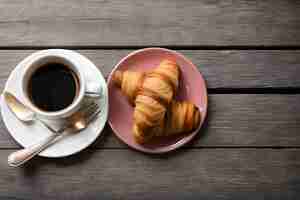 Photo wooden surface with decorative twigs coffee with croissant and flowers