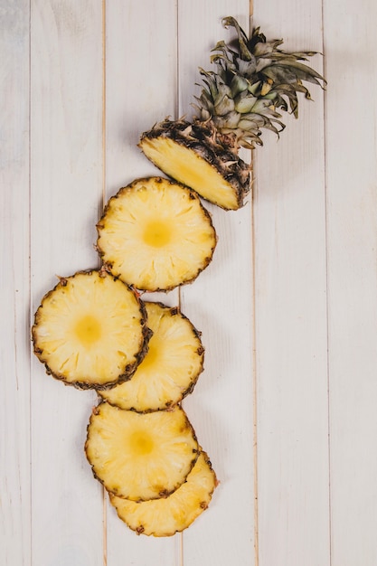 Foto superficie in legno con fette di ananas