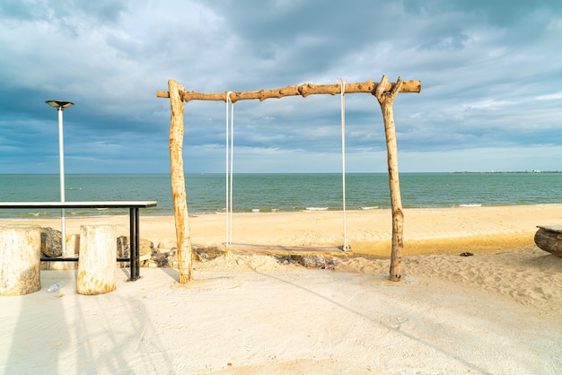 wooden swing on the beach with sea beach background