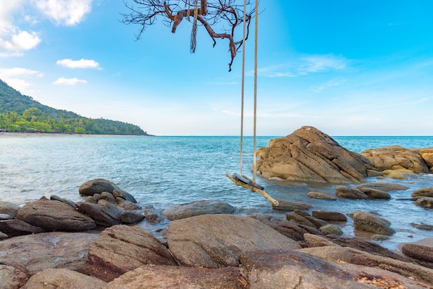 Wooden swing on beautiful rock,beach and sea