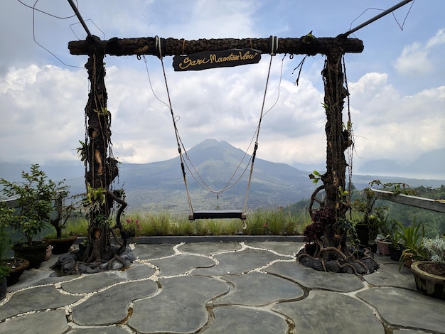 Wooden swing on the rope with view of Batur volcano