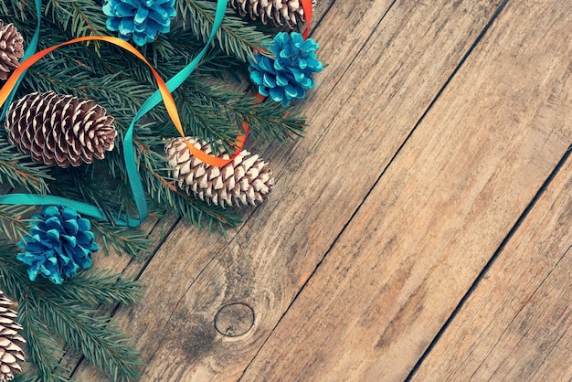 On the wooden table are Christmas tree branches and ornaments.