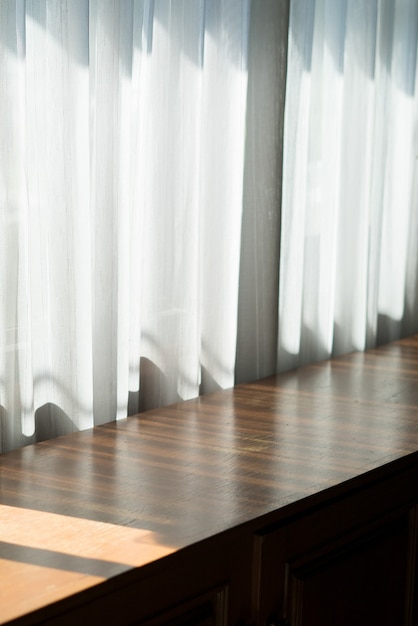 Photo wooden table background by the window on a sunny day.