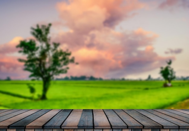 Wooden table and blur of beauty on a sunset day on a field with sky and mountains