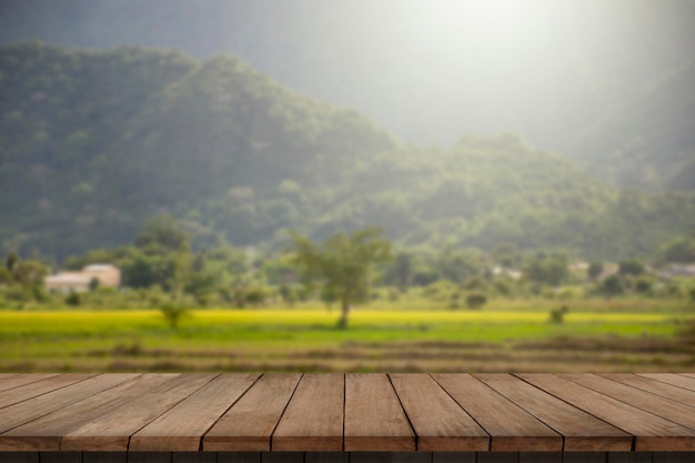 Wooden table and blur of beauty on a sunset day on a field with sky and mountains