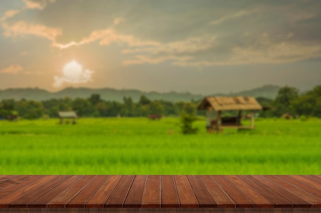 Wooden table and blur of beauty on a sunset day on a field with sky and mountains