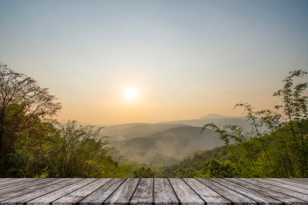 Wooden table and blur of beauty sunset sky and mountains as background