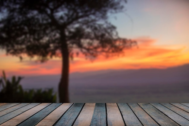 Tavolo in legno e sfocatura del cielo e delle montagne al tramonto di bellezza come sfondo