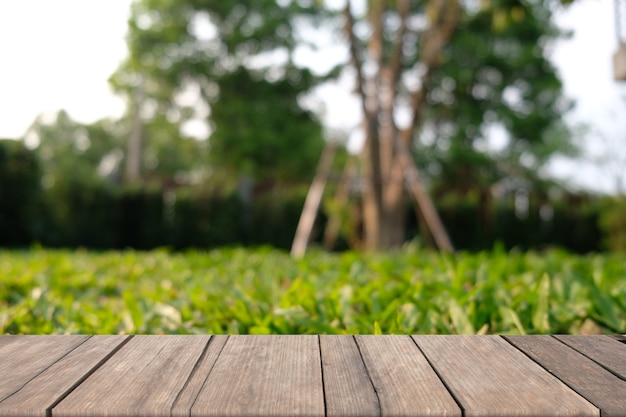 Wooden table of brown on front blurred green field blurred bokeh background