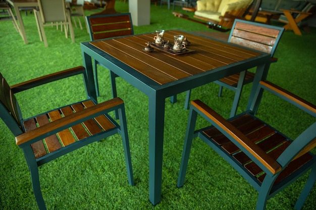 A wooden table and chairs are set up on a green carpeted floor.